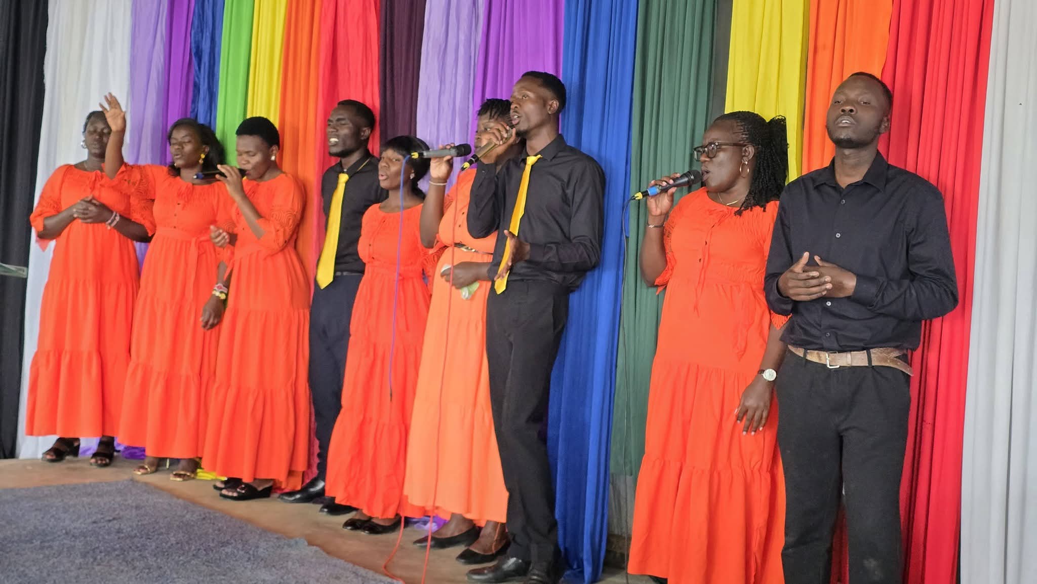 Praise and worship team singing in orange and black
